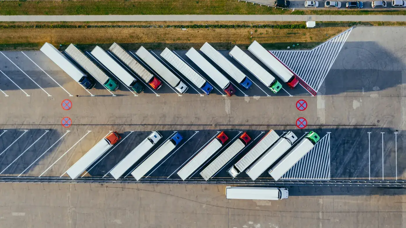 Vue aérienne d'une flotte de semi-remorques rangés sur une plateforme logistique