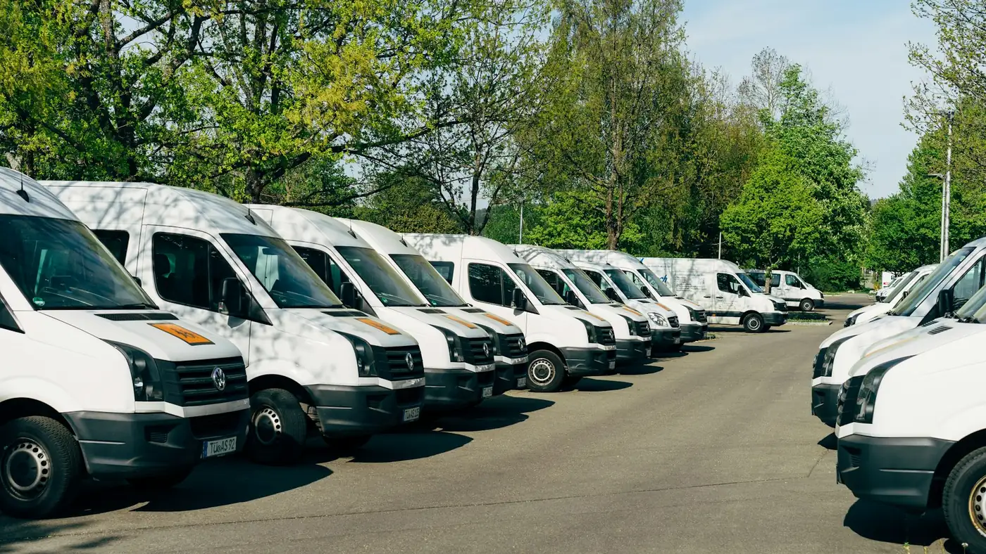 Flotte d'utilitaires d'entreprise alignés sur le parking d'un site