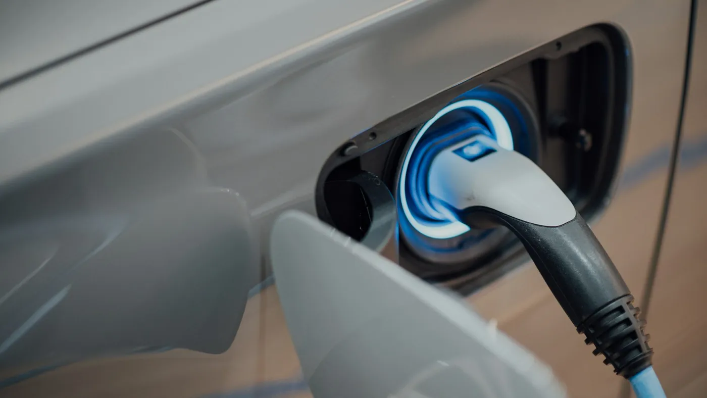 Câble de recharge branché sur la trappe d'un véhicule électrique